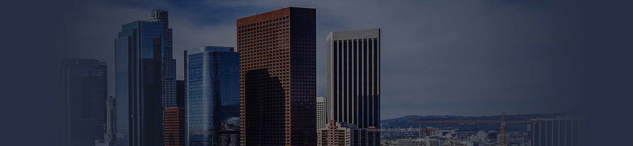 A city skyline featuring modern high-rise buildings against a partly cloudy sky.